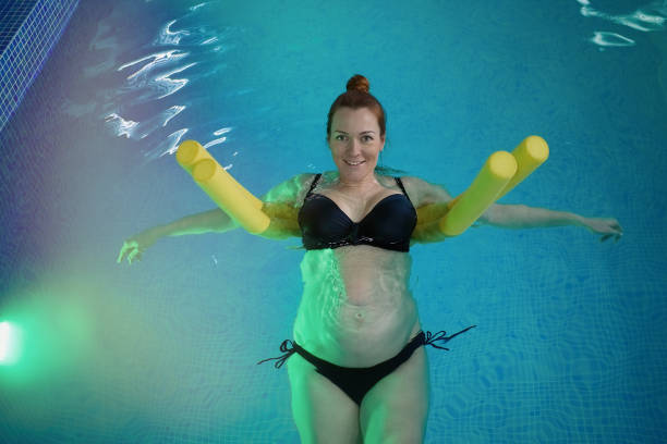 mulher grávida faz seus exercícios de ioga na piscina - 2772 - fotografias e filmes do acervo