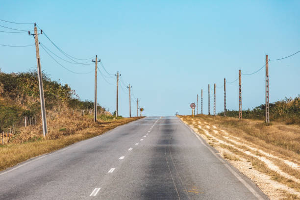 istock Road Amidst Electricity Pylon Against Sky 1310235313