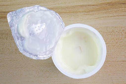 Top view a yogurt on wood table. Polymer plastics food package