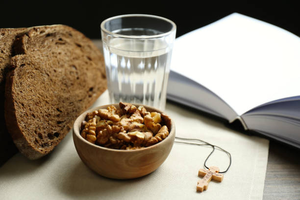 Bread, walnuts, water, Bible and crucifix on table. Great Lent season Bread, walnuts, water, Bible and crucifix on table. Great Lent season fasting stock pictures, royalty-free photos & images