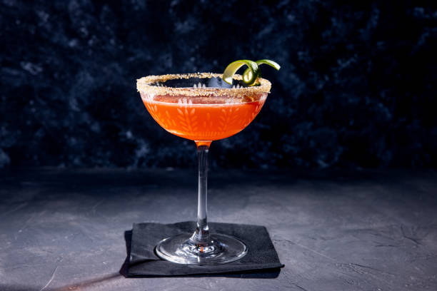 roter cocktail mit limettenschalendekoration und zuckerrand - strawberry daiquiri stock-fotos und bilder