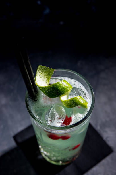 cocktail color menta su ghiaccio decorato con buccia di lime e bacche di ribes - ginger drink alcohol drinking straw foto e immagini stock