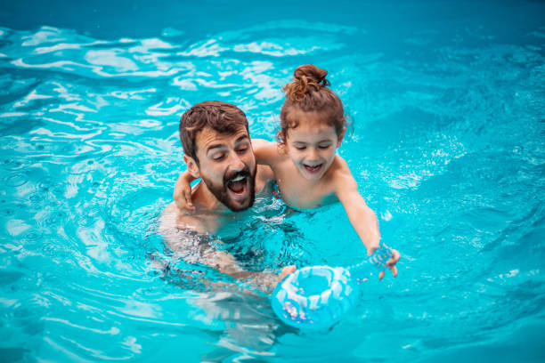 istock Father and son playing together in the swimming pool. 1310240242