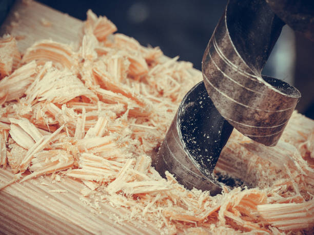 istock Metal machine drilling in wooden board 1310240322
