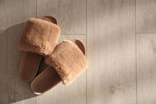 istock Brown fuzzy slippers on floor indoors, flat lay. Space for text 1310241650