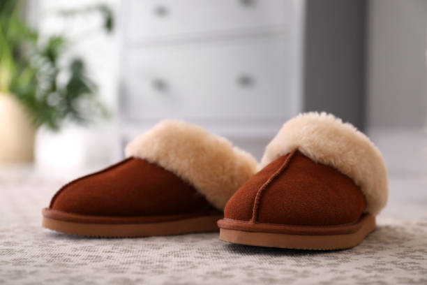 istock Brown warm slippers on floor in room 1310241704