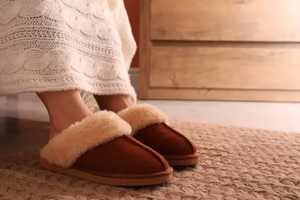 Woman in warm soft slippers at home, closeup