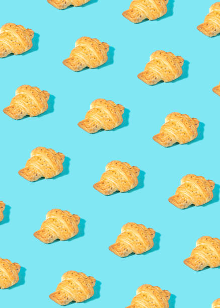 istock Creative pattern made of freshly baked croissant on pastel blue. 1310243393