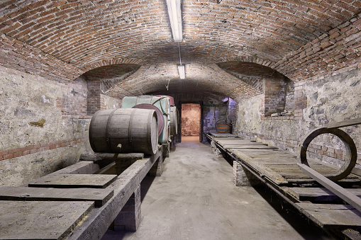 Old cellar with wooden barrels and brick ceiling