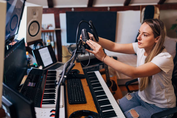 istock Female musician, adjusting the microphone on the microphone stand, in her recording studio, before she start to record her new song 1310243773