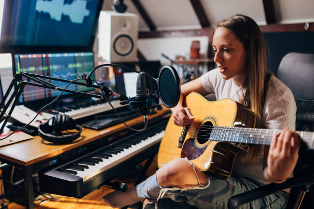 istock In her well equipped recording studio, female guitarist, spending alone time while playing acoustic guitar and singing 1310243900