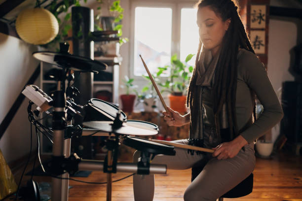 istock Alternative female drummer, enjoying the alone tie while playing drums in her home music studio 1310244140