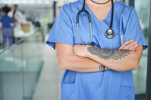Cropped shot of an unrecognizable nurse standing in the clinic during the day with her arms folded