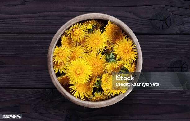 Dandelion In A Wooden Bowl On A Dark Wooden Background Stock Photo - Download Image Now