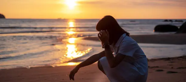 Silhouette of young woman against beautiful sunset at the beach. Travel, relaxing, vacation summer concept