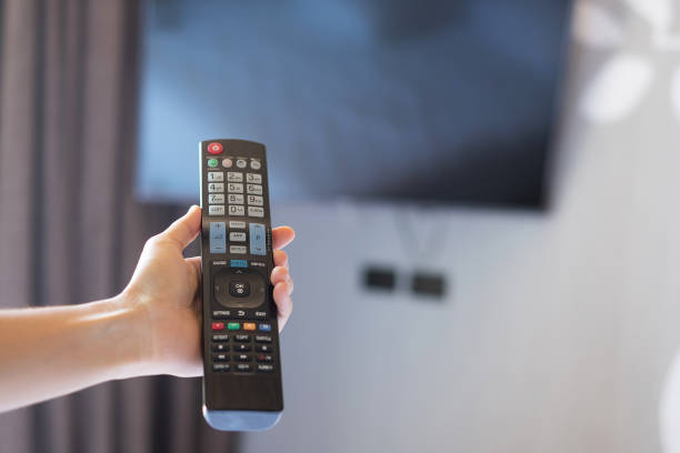 istock hand using remote controller for adjust Smart TV inside the modern room at home or luxury hotel 1310246760