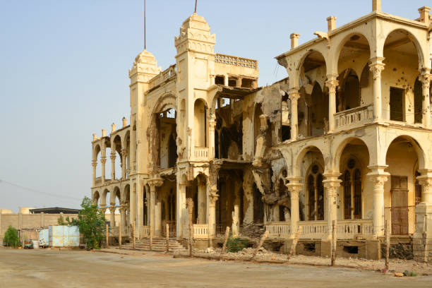 War torn Bank of Italy building (1928), Massawa old town waterfront, Eritrea Massawa, Northern Red Sea Region, Eritrea: ruins of the Palazzo Banca d'Italia, a magnificent Italian colonial building displaying war scars from the independence war, smashed concrete and twisted steel rebar - designed by the engineer Giuseppe Cane in neo-Moorish, it replaced a building in Taulud island destroyed in the 1921 earthquake - located on the corniche, Piazza Principe di Piemonte / Baratieri - Batse island, the old town construction material torn run down concrete stock pictures, royalty-free photos & images