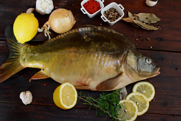 istock Fresh raw carp fish on wooden background 1310252731