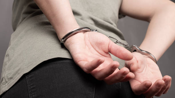 istock prisoner woman, prisoner's hands are handcuffed behind her back 1310252863