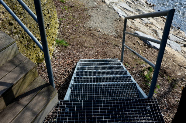 istock stair construction with railing with high resistance to deformation even under high load galvanized steel floor grate and railing. concrete blocks and willows by the river 1310253507