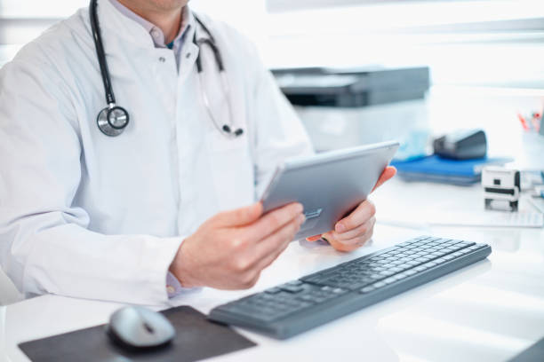 istock Midsection of physician with digital tablet at his desk 1310253884