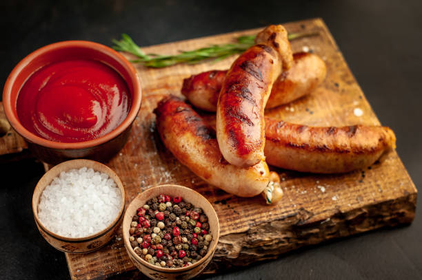 istock grilled sausages with spices and ketchup on a stone table 1310255071