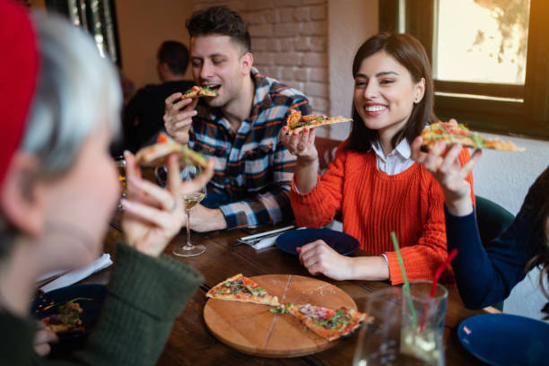istock Cheerful young friends eating pizza in a restaurant 1310255523