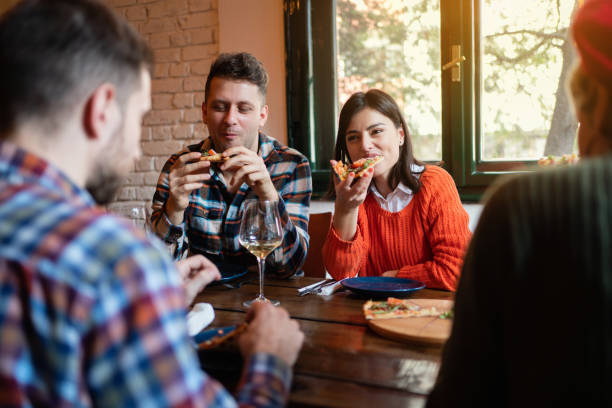 istock Group of young happy eating pizza in a restaurant 1310255530