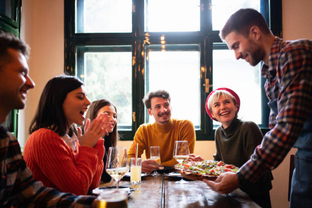 istock Waiter bringing food at the table in a restaurant 1310256105