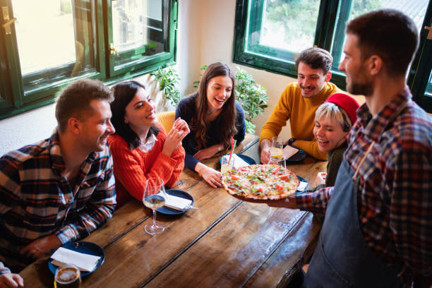 istock Waiter bringing pizza at the table in a restaurant 1310256114