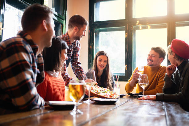 istock Young friendly waiter bringing food at the table in a restaurant 1310256116