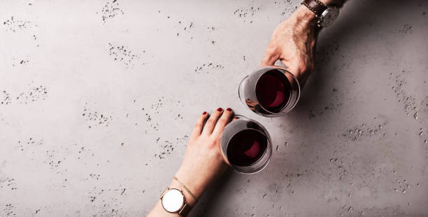 casal (homem e mulher) bebendo vinho tinto em um encontro. mãos segurando óculos. - wine red wine glass bar counter - fotografias e filmes do acervo