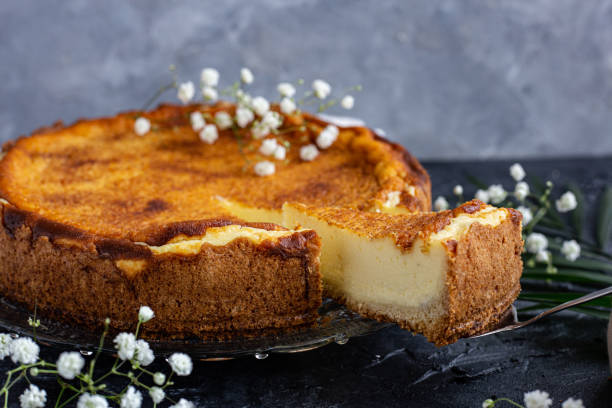 istock Cheesecake on a plate decorated with white flowers. Single piece coming out. 1310262273