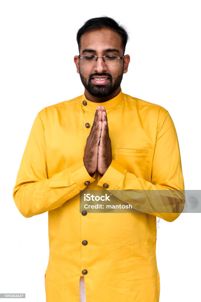 Praying to Bhagwan! Young man in prayering in traditional yet stylish Indian men's wear which is called Kurta Pyjama. Isolated on white background. Culture of India Stock Photo