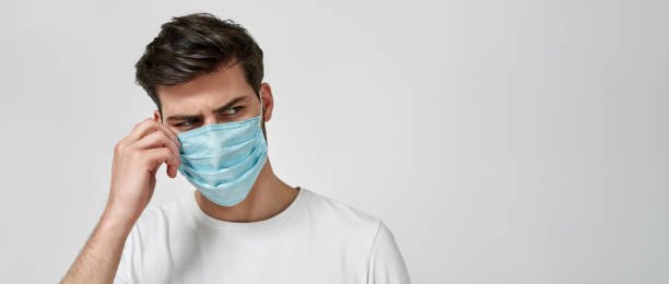 istock Young man wearing medical mask looking away 1310265066