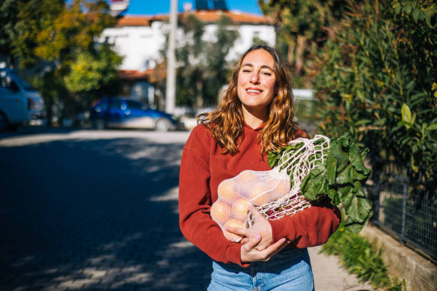 mulher comprando frutas e legumes com algodão eco reutilizável. conceito de estilo de vida de desperdício zero - groceries women bag customer - fotografias e filmes do acervo