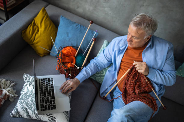 istock Senior man watching online tutorial to learn to knit at home 1310267346