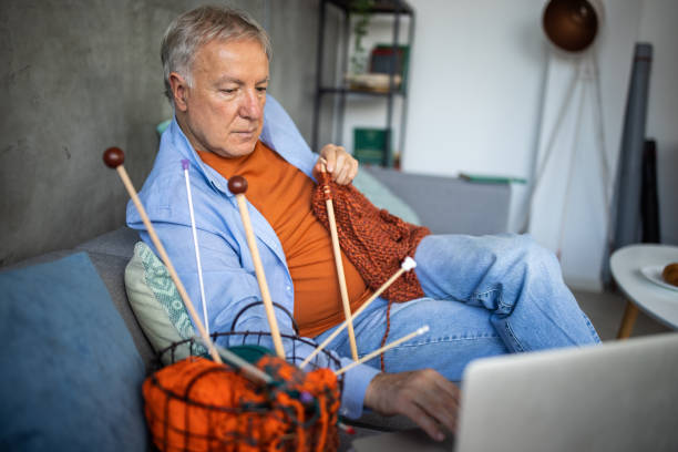 istock Senior man watching online tutorial to learn to knit at home 1310267370