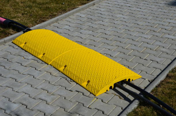 voltage, high, architecture, barrier, bicycle, bike, black, bridge, cable, cables, car, connecting, cover, designed, electric, electricity, electronic, five, floor, gray, hose, line, obstacle, paved, pavement, paving, pedestrian, pedestrians, protect, protective, resistant, road, safe, safety, scratch, sidewalk, stone, street, surface, switchboard, through, tiles, traffic, tray, tunnel, visible, walkway, water, way, yellow conectar cables de electricidad a través de la carretera pavimentada a pie de la acera. una forma segura de proteger el cable o la manguera. coches, bicicletas y peatones pueden caminar sobre un obstáculo amarillo visible desde la centralita