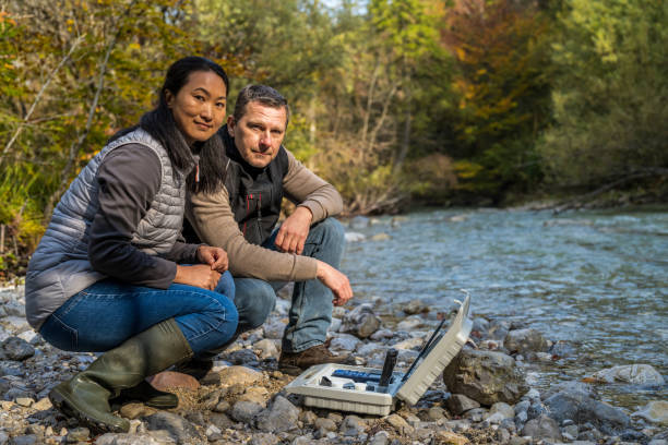 istock Biologists with water testing equipment crouching near river 1310268958