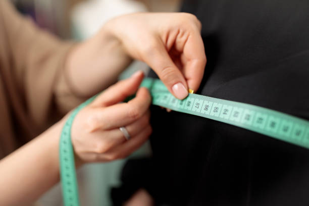 istock A centimeter is a tailor's tool for measuring when sewing. A centimeter is a tool for measuring dimensions. A meter for sewing clothes. Tailoring for the tailor. Human hands. 1310269601