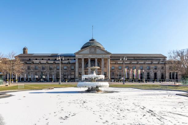 fountain in front of the wiesbadener casino in ice Wiesbaden, Germany - February 12, 2021: fountain in front of the wiesbadener casino in ice in winter time with casino in background with inscription Aquis Mattiacis (water of the Mattiacis people). kurhaus casino stock pictures, royalty-free photos & images