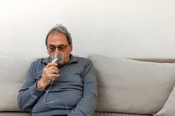 istock Senior man using medical equipment for inhalation with respiratory mask. 1310270090