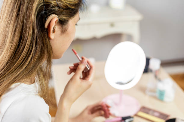 istock Young woman with hearing aid makeup at home 1310270405