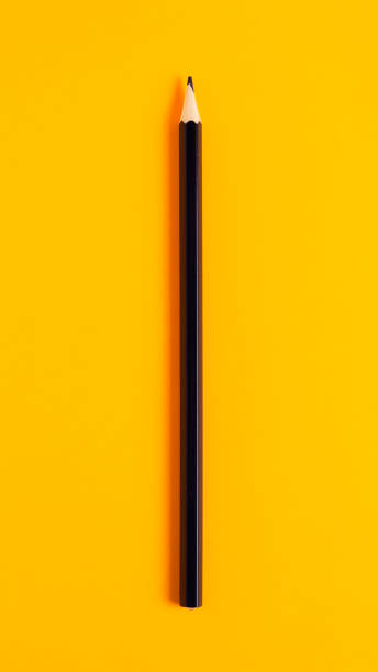 istock Black pencil on an orange background close-up 1310271698