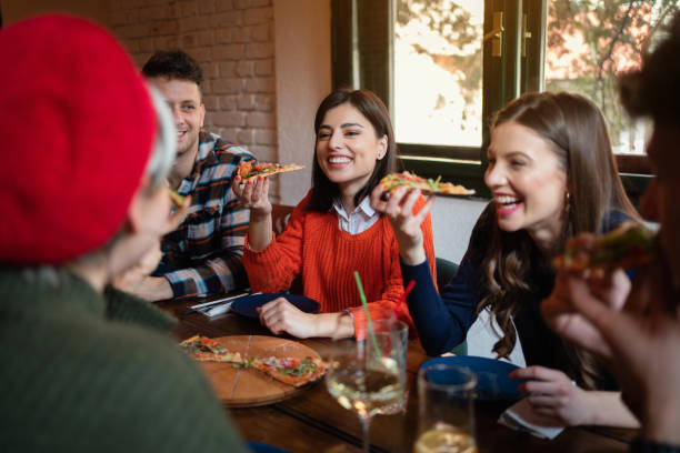 istock Happy friends eating pizza in a restaurant 1310272455