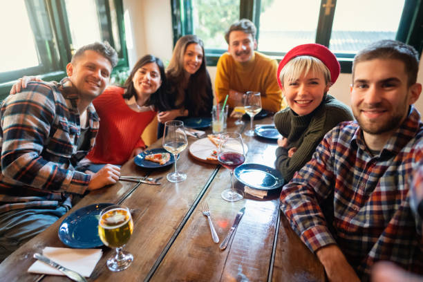 istock Cheeful group of friends taking selfie with smart phone in a restaurant 1310272464