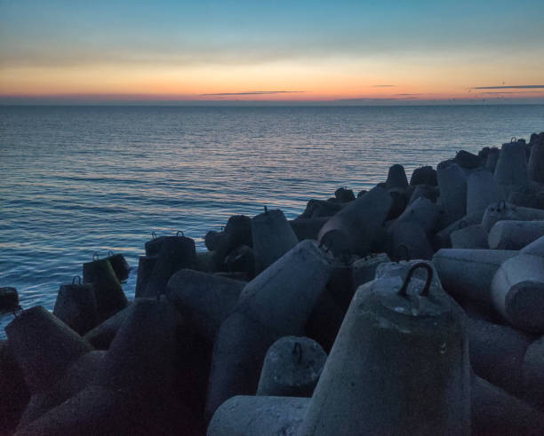 istock Concrete breakwaters on the dam. Sunset on the Baltic Sea. 1310272476