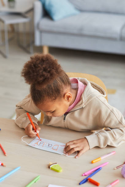istock Girl Decorating Face Mask for Dad 1310274169