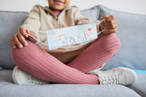 istock Girl Holding Face Mask for Dad 1310274176